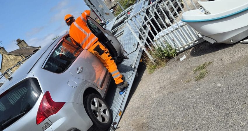 Car being recovered onto a flatbed recovery truck